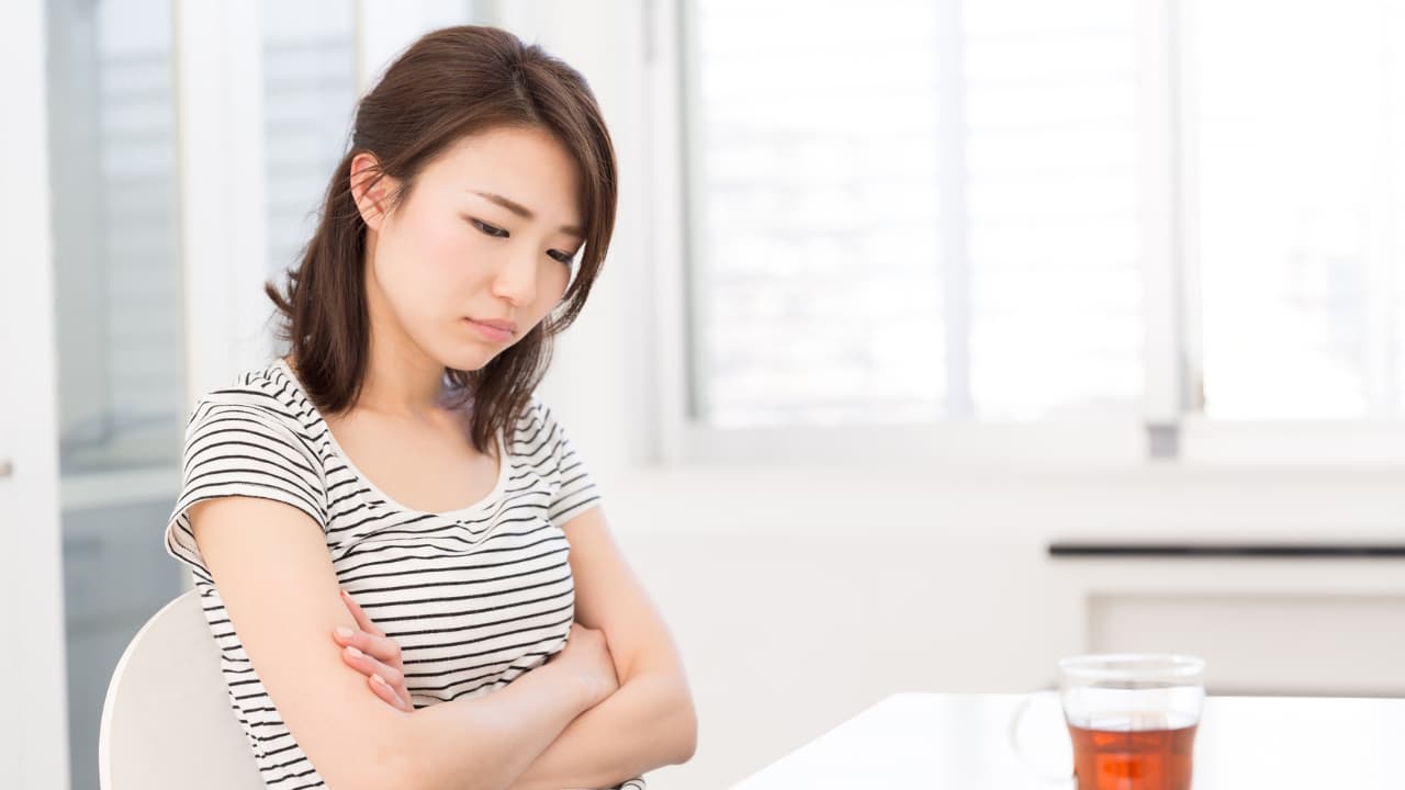 腕を組んで困る女性