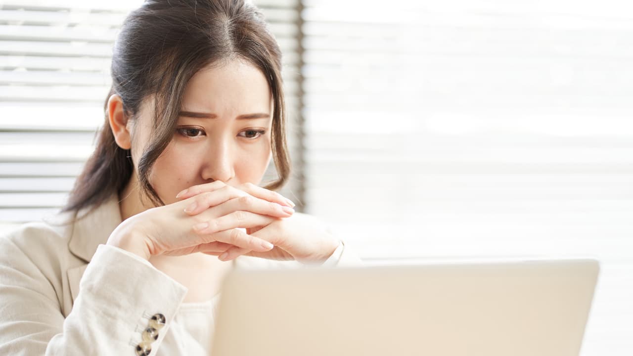 PCの前で困り顔の女性